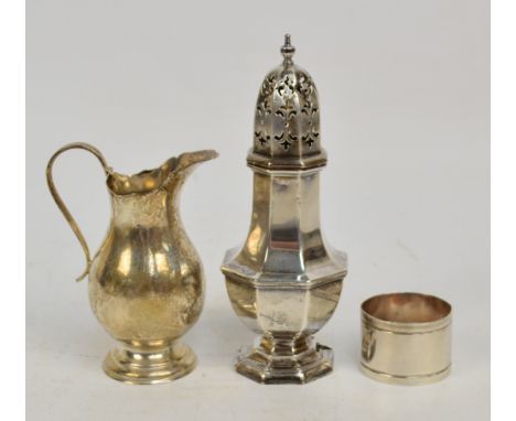 A George V hallmarked silver sugar caster of octagonal baluster form with pierced domed cover and cast finial, raised on step