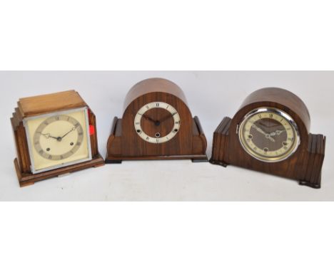 An Art Deco style oak mantel clock, the square face set with silvered chapter ring with Roman numerals, height 20cm and two m