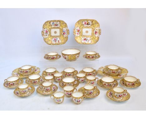 A mid 19th century porcelain tea service with hand painted floral panels on yellow ground with gilt heightened scrolls and or