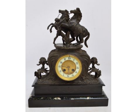 A late 19th century French black slate, marble and spelter mantel clock, the surmount modelled as rearing horses above a circ