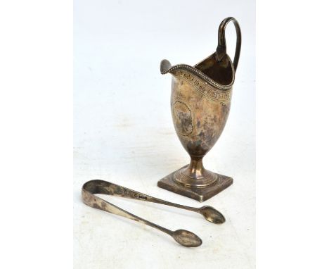 A George III hallmarked silver helmet shaped cream jug with bright cut decorated beaded rim, centred with octagonal cartouche