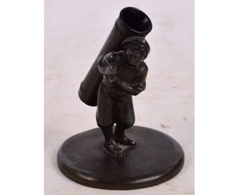 An early 20th century golfing pen holder modelled as a caddy carrying an oversized bag acting as the pen receptacle, mounted 