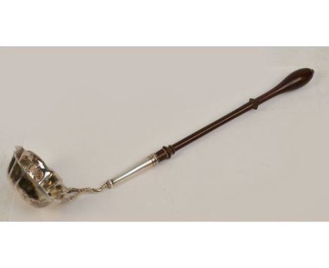 A George II hallmarked silver toddy ladle with shaped oval bowl, lip to one side and turned wooden handle, maker's mark parti