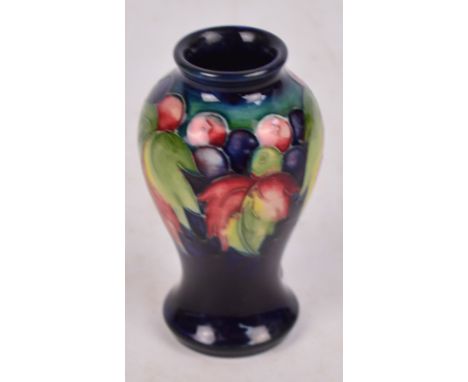 A small Moorcroft vase of baluster form with tubeline decoration in the "Leaf and Berry" pattern, impressed stamp and facsimi