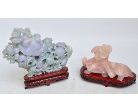 A carved pink quartz figure group depicting two tortoises; one carrying a button hook and tokens on its back, width 21cm, and