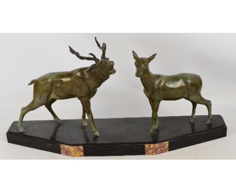 A French Art Deco bronze mantelpiece depicting a stag and a hind, on black and pink marble trapezoidal base, height 35.5cm, l