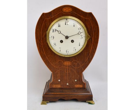 An Edwardian Art Nouveau oak, satinwood and mother of pearl inlaid mantel clock, the white enamelled dial set with Arabic num