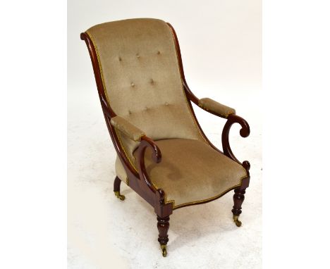 A Victorian button upholstered scroll back armchair on carved and turned front supports, on castors, width 61cm.