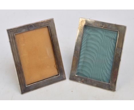 A pair of George V hallmarked silver photograph frames of rectangular form with engine turned decoration, centred with circul