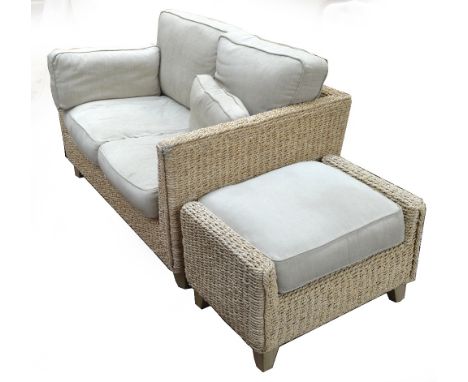 A wicker two seater sofa and matching footstool (2).