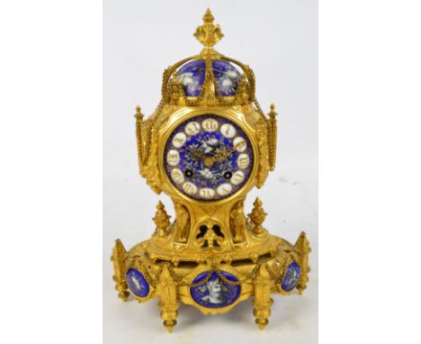 A 19th century French ormolu and porcelain mounted mantel clock, the plaques, dial and dome decorated with armour, weapons, a