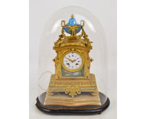 A 19th century French gilt bronze mantel clock with inset porcelain panels depicting floral motifs and river landscape with m