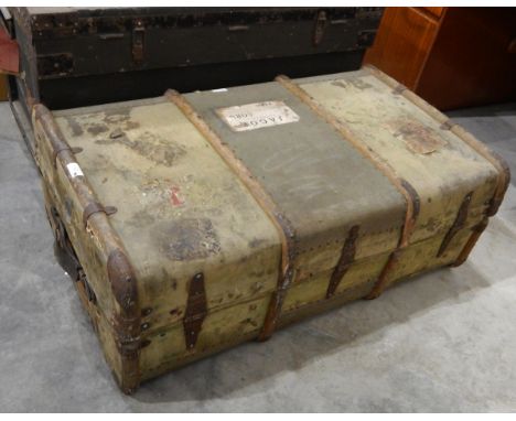 A wood-bound canvas cabin trunk bearing luggage labels 