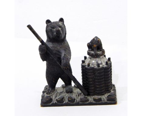 A Black Forest carved bear inkstand, the inkwell in the form of basket with glass liner and carved bear stopper, flanked by s