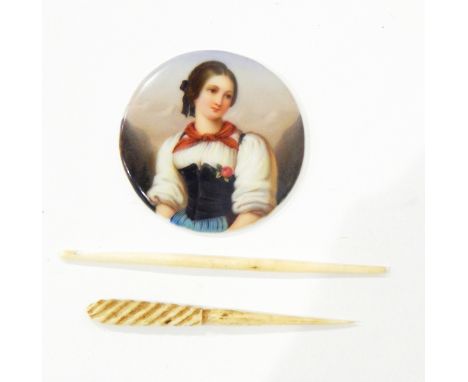 A handpainted porcelain circular plaque, half-length portrait of 19th century lady in peasant style dress and two bone sewing