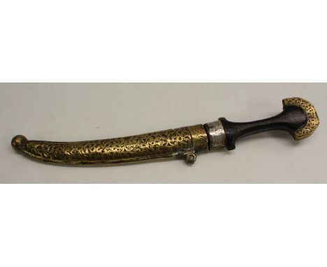 A Middle Eastern kindjahl dagger, 23cm curved blade, hardwood grip, the brass scabbard and mounts chased with flowering scrol
