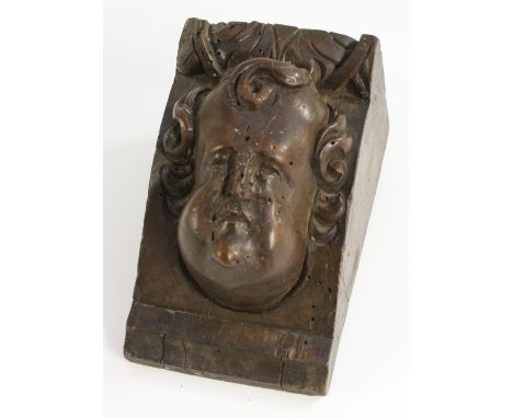 A 17th century walnut sculptural architectural fragment, carved with a putto mask, 12cm x 7.5cm, c.1680