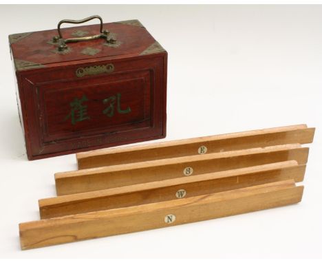 A Chinese mah-jong set, the hardwood cabinet with sliding door enclosing five long graduated drawers housing bone and bamboo 