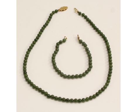 A 9ct gold mounted Chinese jade bead necklace, 44.5cm long; a bracelet, similar, 18.5cm long (2)