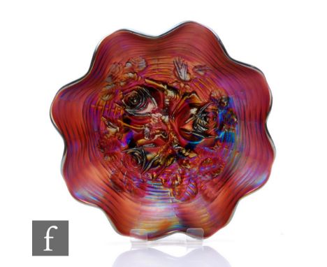 An early 20th Century Carnival glass footed bowl with wave edged rim, by Northwood, relief moulded to the central well in the
