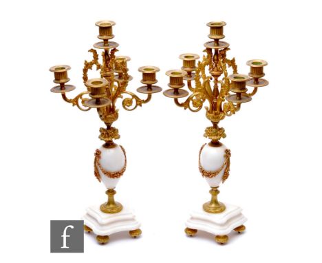 A pair of early 20th Century French white marble clock garnitures of candelabra form on shaped stepped bases, height 47cm. (2