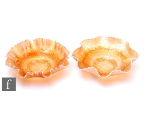 Two early 20th Century Carnival glass footed bowls with wave edged rim, by Fenton, each relief moulded to the central well in