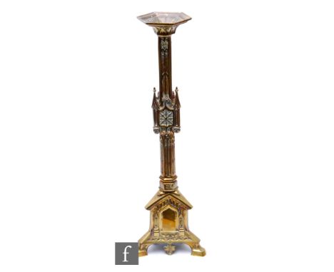 An early 20th Century brass alter candlestick of ecclesiastical form, on gothic tricorn base, height 59cm. 