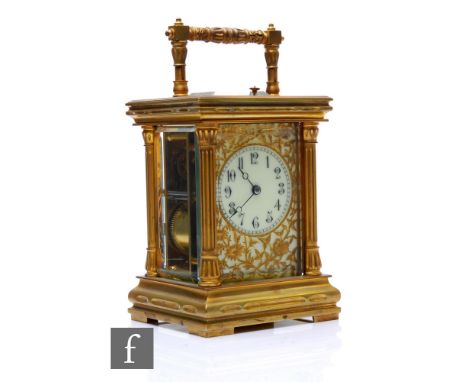 A 19th Century brass carriage clock with push button repeat, the Arabic dial and pierced floral face enclosed by a bevelled g