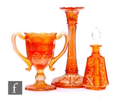 Three pieces of early 20th Century carnival glass in marigold, a loving cup by Fenton relief moulded in the Orange Tree patte