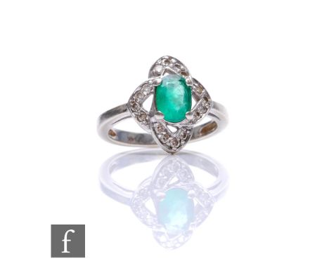 A 14ct white gold emerald and diamond ring central oval emerald within a shaped diamond set border, weight 3.6g, ring size K.