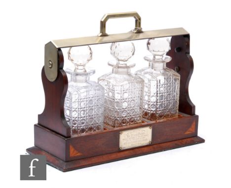 An Edwardian inlaid walnut three bottle tantalus with plated mounted handle on plinth base with key, width 38cm. 