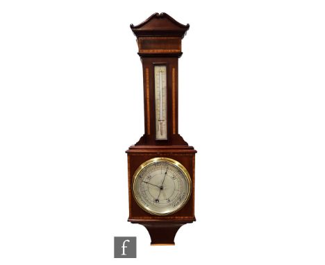 An Edwardian mahogany and satinwood crossbanded aneroid barometer incorporating a thermometer below a scroll pediment, height