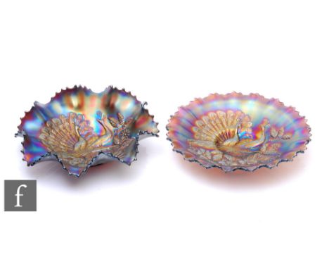 Two early 20th Century Carnival glass footed bowls with wave edged rims, by Northwood, each relief moulded to the central wel