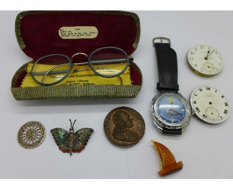 A Russian wristwatch, two pocket watch movements, spectacles, a silver and enamel butterfly brooch, seal, etc.