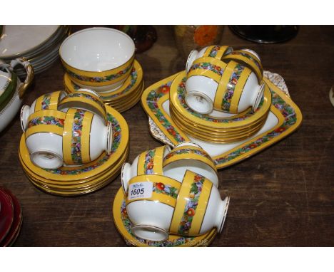 A Wedgwood bone china part Teaset, mark C1910, yellow banded with fruit decoration including twelve each of cups, saucers, te