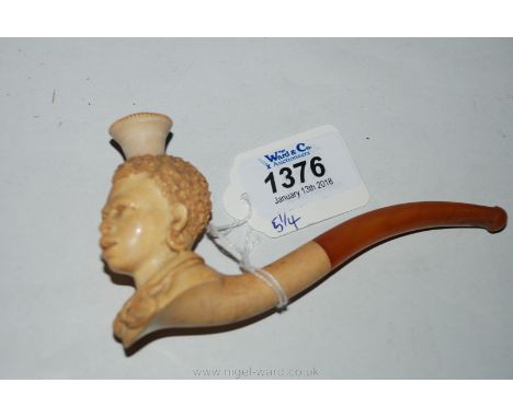 An unused carved Ivory Pipe in the form of a Negress, with amber coloured stem and mouthpiece, 5 1/4" long