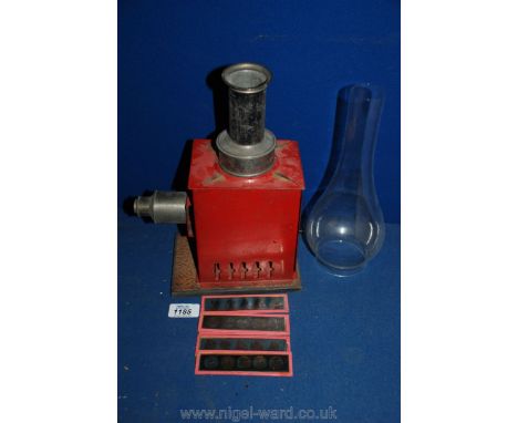 A child's tin plate Magic Lantern with oil lamp and five glass plates, also an oil lamp chimney
