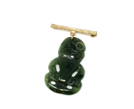 A Maori jade tiki suspended on 9ct gold bar brooch