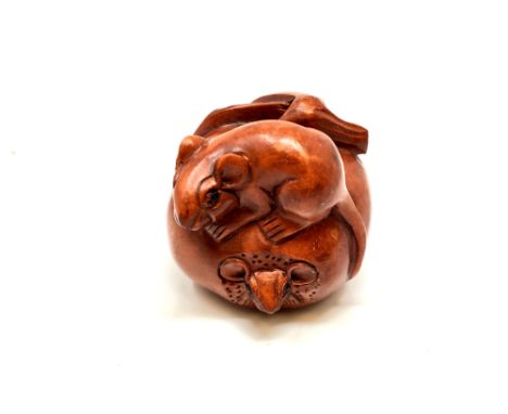 A carved Chinese wooden netsuke, rats on fruit  