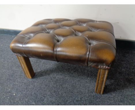 A brown button leather Chesterfield footstool on wooden legs 