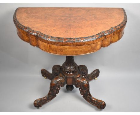 A 19th Century Burr Walnut Card Table with a Folding Carved Serpentine Top over a Shaped Frieze an Supported on a Carved Colu