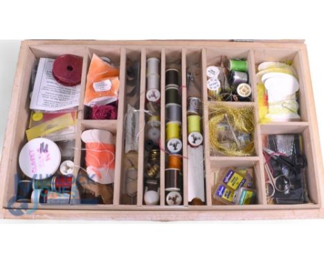 An assortment of fly tying materials including silks, feathers, wool, packets of dyed materials, a few assorted tools, all he