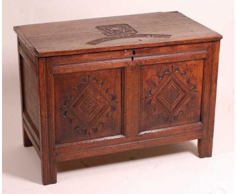 A 17th century joined oak two-panel coffer, the two plank top blind carved with a portrait of Oliver Cromwell bearing arms, a