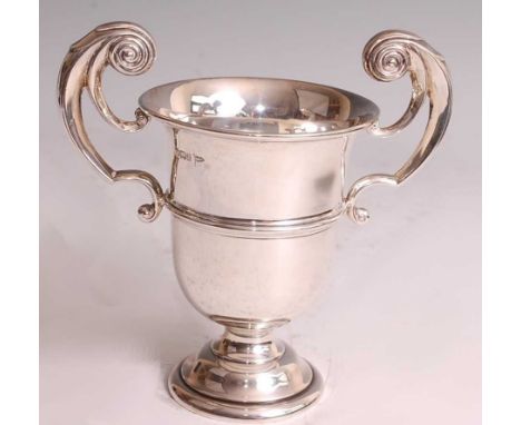 An Edwardian silver pedestal trophy cup by Walker &amp; Hall, having plain banded body to a stepped foot, with S-scroll handl