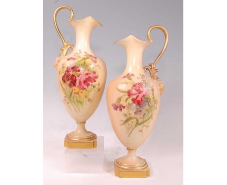 A pair of Edwardian Royal Worcester porcelain pedestal ewers, hand-painted floral decoration on a blush ivory ground, heighte