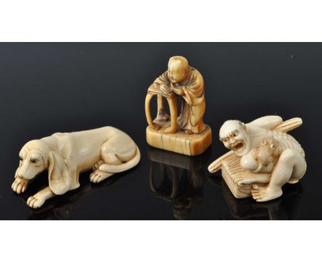 A Japanese Meiji period carved ivory netsuke of a rat-catcher, signed verso, 4cm; together with one other of a recumbent houn