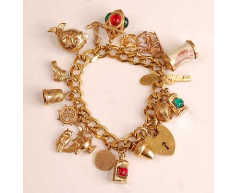 A 9ct yellow gold curblink bracelet, with padlock clasp and safety chain, 17 charms attached to include an acorn, lantern, St