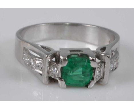 A white metal, synthetic emerald and diamond ring, comprising a centre octagonal cut synthetic emerald in a square claw setti