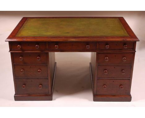 A Victorian oak twin pedestal desk, having a gilt tooled leather inset writing surface above three frieze drawers, the pedest