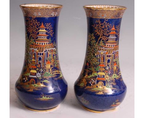 A near-pair of 1920s Carltonware porcelain vases, of lower bellied form with slightly flaring rims, blue lustre glaze, gilt a